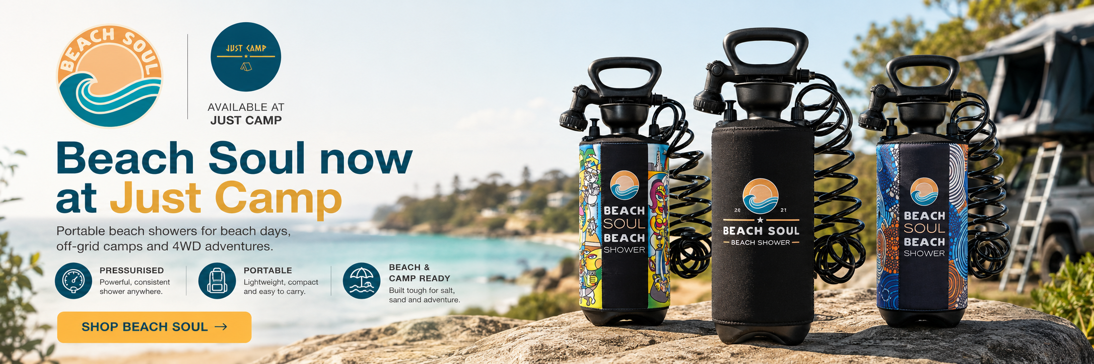 Three portable beach showers from Beach Soul are displayed outdoors on a rock by a lake, with a campsite and trees in the background. The products are shown in black, dark gray, and blue colors with colorful graphic patterns on the shower heads.